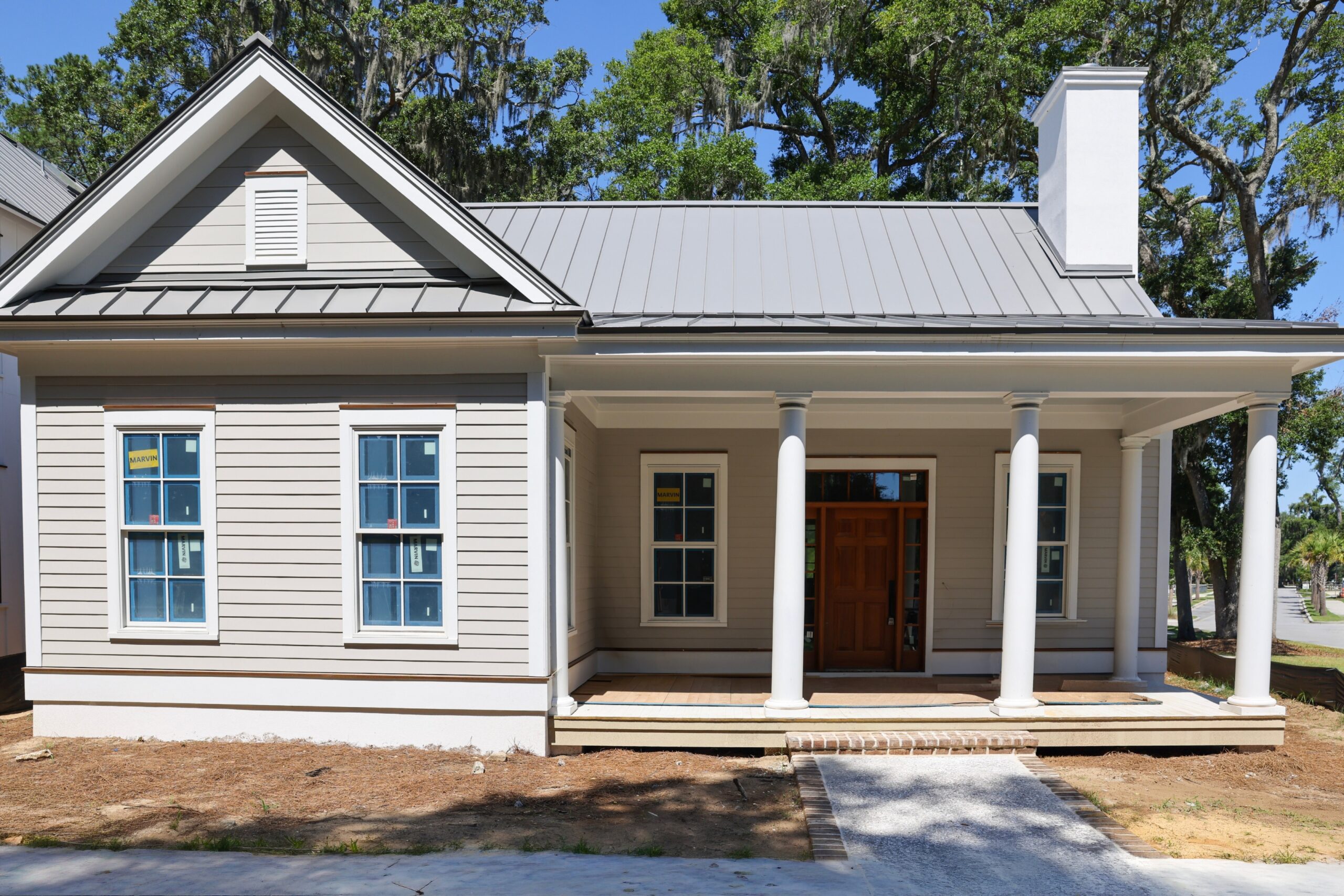 New construction Lowcountry home in Whitehall Point on Lady's Island, featuring a welcoming front porch, coastal architecture, open-concept design, and luxury finishes near historic downtown Beaufort, South Carolina.