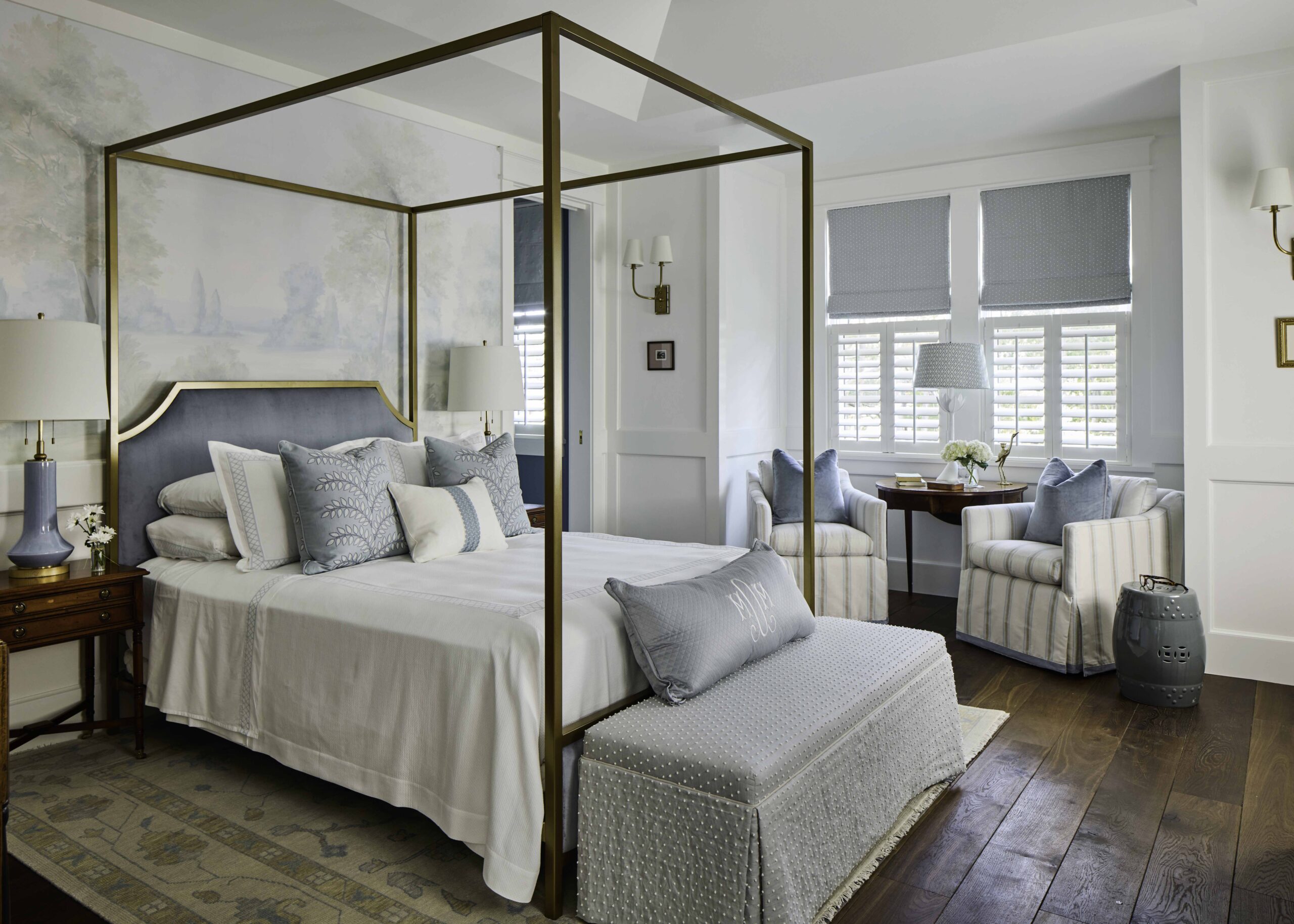Primary bedroom with a brass canopy bed and soft blue-and-white decor in the 2025 Southern Living Showcase Home in Habersham, SC, built by Allen Patterson Builders