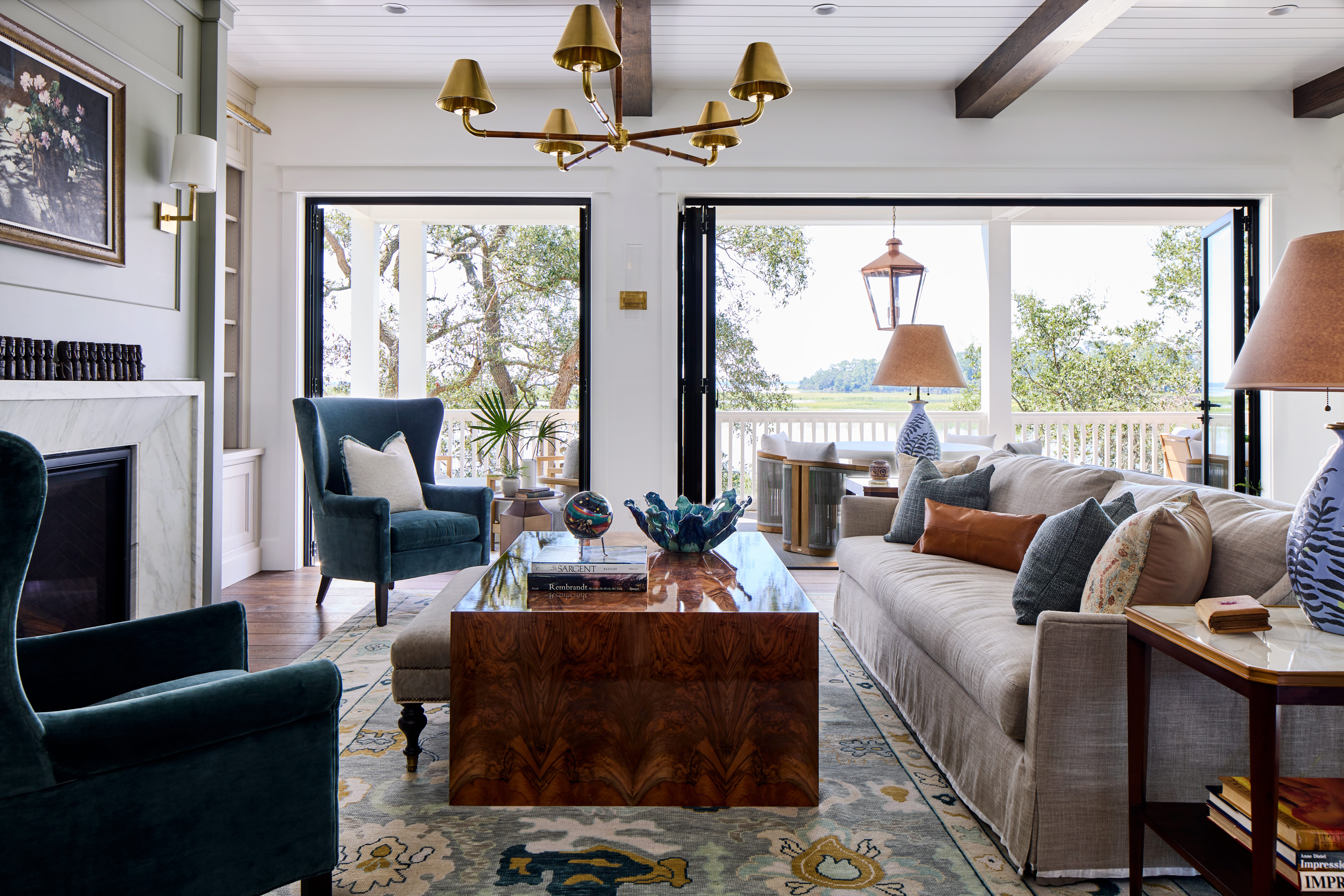 Covered waterfront porch in the Habersham Showcase Home with a round dining table, woven chairs, copper lantern, and marsh views of the Lowcountry, Habersham, SC