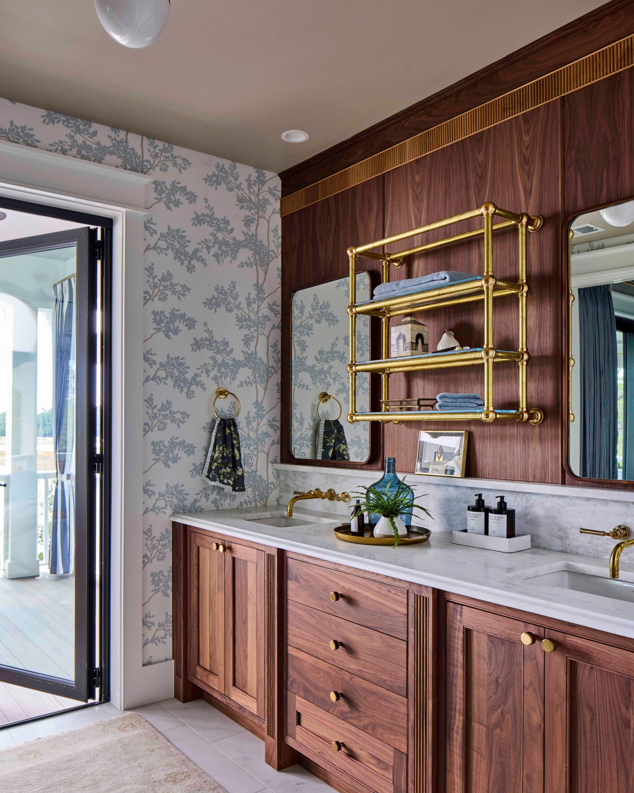 Primary bathroom with walnut vanity, marble counters, and brass fixtures in the 2025 Southern Living Showcase Home in Habersham, SC, built by Allen Patterson Builders