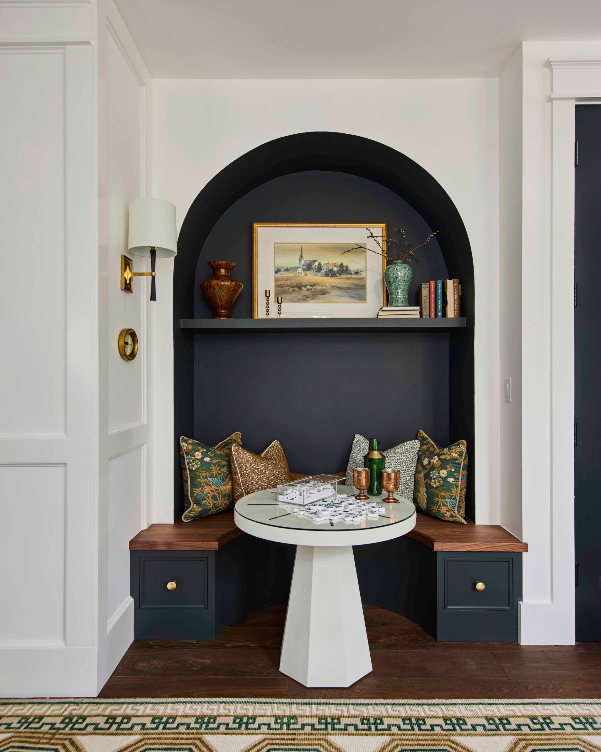 Arched built-in nook with a bench seat, display shelf, and brass sconce in the 2025 Southern Living Showcase Home in Habersham, SC, built by Allen Patterson Builders