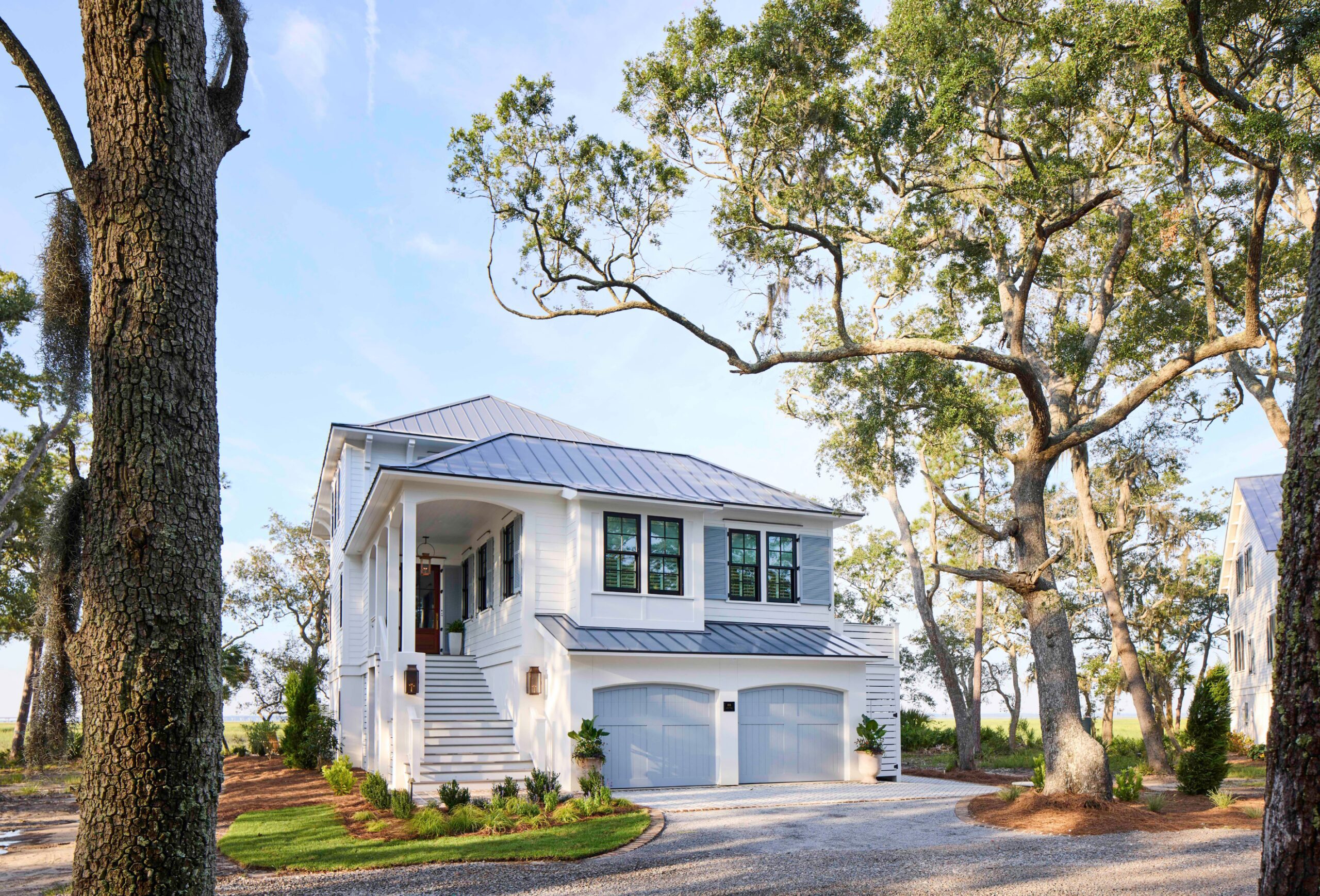 Elevated white coastal home with double porches and metal roof, built by Allen Patterson Builders as the 2025 Southern Living Showcase Home in Habersham, SC