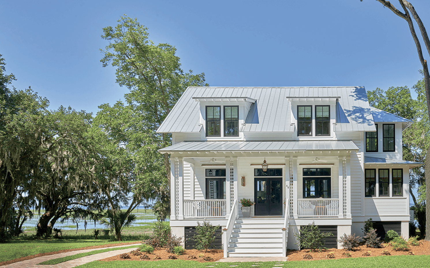 Two-story white coastal home with double front porches built by Allen Patterson Builders, the 2018 Coastal Living Idea Home