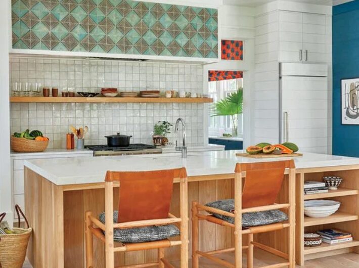 Kitchen in the 2018 Coastal Living Idea House with a wood-and-marble island, leather stools, open shelving, and a green tile backsplash