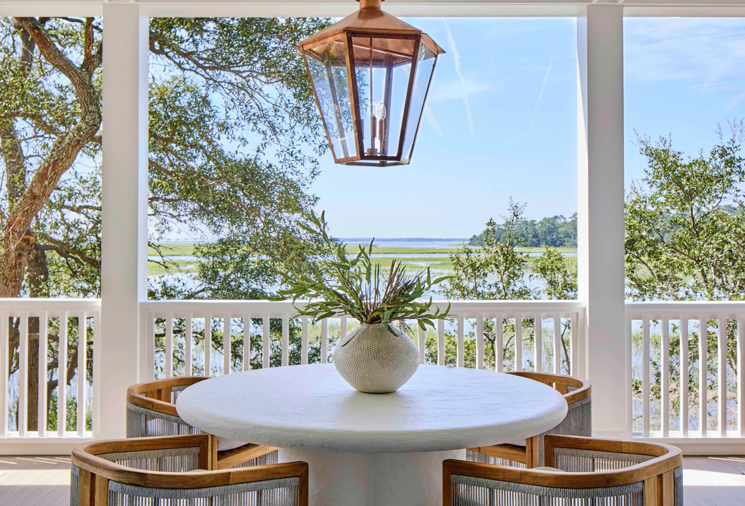 Covered front porch with columns and hanging lanterns at the 2025 Southern Living Showcase Home in Habersham, SC, custom built by Allen Patterson Builders