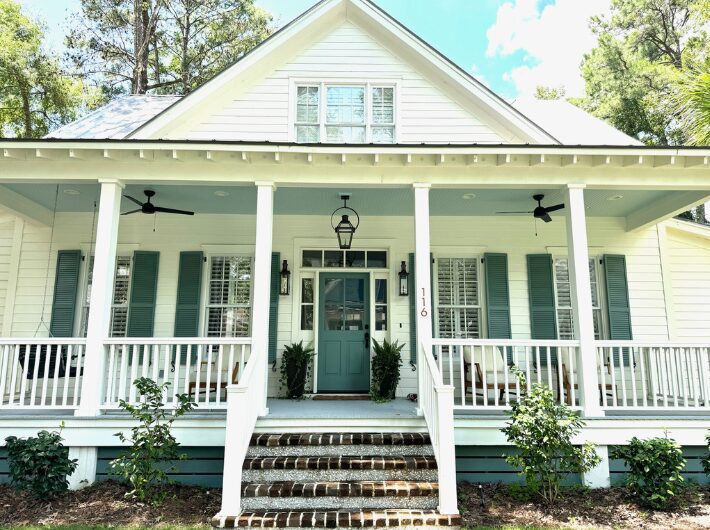 Home Facade with White Siding, Wooden Doors, and A Metal Roof by Allen Patterson Construction.